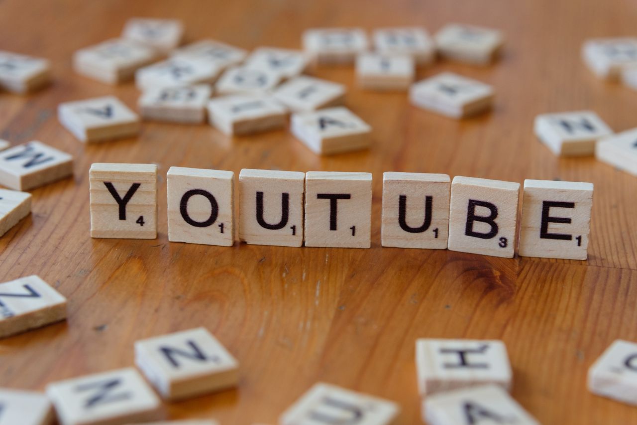 project-03-a Wooden letter tiles spelling YOUTUBE on a wooden surface, symbolizing video sharing and streaming.
